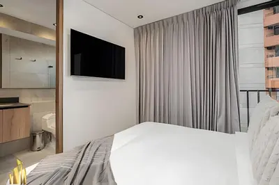 a bedroom with a bed and a television on a wall at Morph 1101 - Sophisticated & brigh apt/ BBQ in El Poblado
