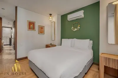 a large white bed in a room with a green wall at Morph 1201 - Elegant/Modern Apt in Poblado in El Poblado