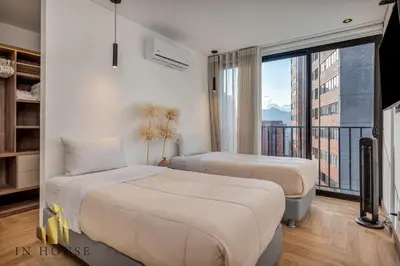 two beds in a room with a balcony at Morph 1201 - Elegant/Modern Apt in Poblado in El Poblado
