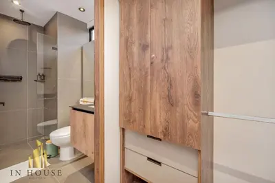 a bathroom with a wooden door next to a toilet at Morph 1201 - Elegant/Modern Apt in Poblado in El Poblado