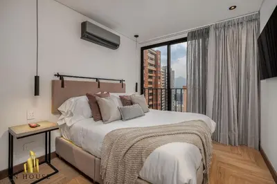 a bedroom with a bed and a large window at Morph 1202 - Stylish City Living: Modern Apt in El Poblado
