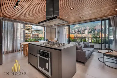 a kitchen with a stove top oven next to a living room at Morph 1301 - Chill Haven BBQ, Jacuzzi, AC in El Poblado