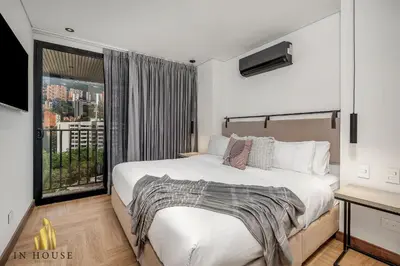 a bedroom with a large bed and a window at Morph 1302 - Spacious & private apt w BBQ/Jacuzzi in El Poblado