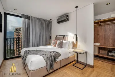 a bedroom with a large bed and a large window at Morph 1302 - Spacious & private apt w BBQ/Jacuzzi in El Poblado