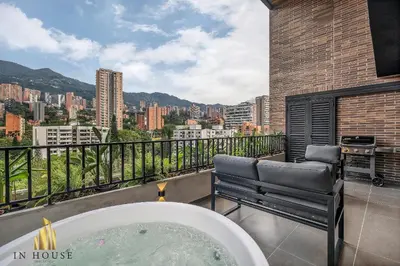 a bath tub on a balcony with a view of a city at Morph 1302 - Spacious & private apt w BBQ/Jacuzzi in El Poblado