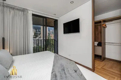 a bedroom with a bed and a tv on a wall at Morph 1401 - Luxe & bright ap in Poblado with AC in El Poblado