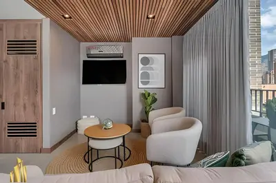 a living room with a couch and a table and chairs at Morph 1402 - Stylish apt in Poblado/AC/Jacuzzi in El Poblado
