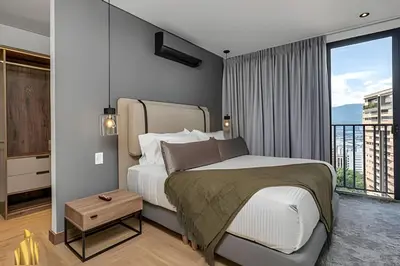 a bedroom with a large bed and a balcony at Morph 1402 - Stylish apt in Poblado/AC/Jacuzzi in El Poblado