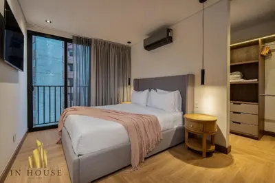 a bedroom with a large bed and a large window at Morph 1601 - Exclusivity in Poblado/Jacuzzi in El Poblado