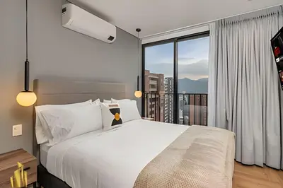 a bedroom with a large bed and a large window at Morph 1602 - Luxury escape in Poblado/Jacuzzi/AC in El Poblado