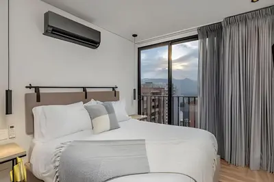 a bedroom with a bed and a large window at Morph 1802 - Stylish Escape in Poblado AC/Jacuzzi in El Poblado