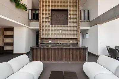 a lobby with white furniture and a clock on the wall at Morph 1901 - Cozy Space with priv Balcony/BBQ in El Poblado