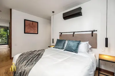a bedroom with a large white bed with blue pillows at Morph 201 - High ceilings & modern apt/BBQ in El Poblado
