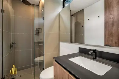 a bathroom with a sink and a toilet and a mirror at Morph 201 - High ceilings & modern apt/BBQ in El Poblado