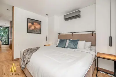 a bedroom with a large white bed with blue pillows at Morph 201 - High ceilings & modern apt/BBQ in El Poblado