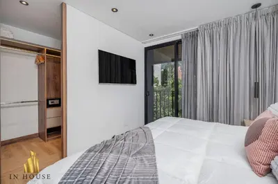 a bedroom with a white bed and a window at Morph 302 - Modern apt high ceilings BBQ/Jacuzzi in El Poblado