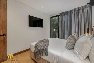 a bedroom with a white bed and a large window at Morph 401 - Modern apt High Ceilings BBQ/Jacuzzi in El Poblado