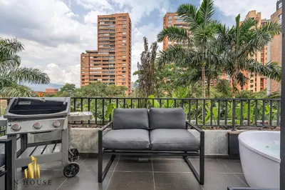 a chair sitting on a patio with a grill and a tub at Morph 501 - Spacious Cozy Apt Poblado/BBQ/Jacuzzi in El Poblado