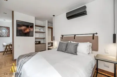 a bedroom with a large white bed and a tv at Morph 502 - Bright & Spacious, Poblado/BBQ/Jacuzzi in El Poblado