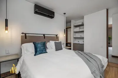 a bedroom with a large white bed with blue pillows at Morph 701 - Spacious apt City View Haven in El Poblado