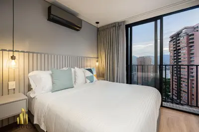 a bedroom with a large bed and a large window at Morph 902 - Luxury Apt in Poblado with Balcony in El Poblado