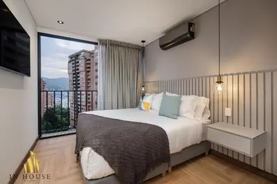 a bedroom with a bed and a large window at Morph 902 - Luxury Apt in Poblado with Balcony in El Poblado