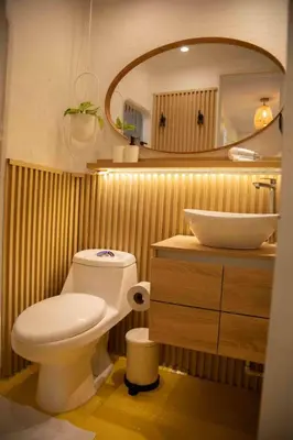 a bathroom with a toilet and a sink and a mirror at Poblado-Manila encantador apartamento in Medellín