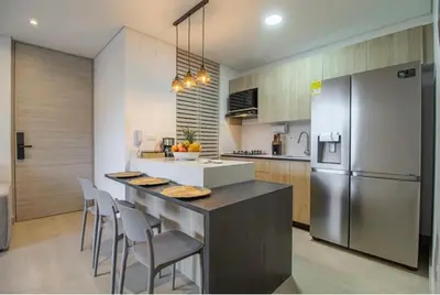 a kitchen with a counter with chairs and a refrigerator at Beautiful apartment in Poblado in Medellín