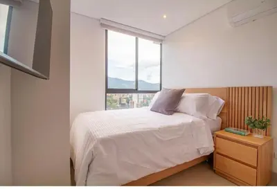 a bedroom with a bed and a large window at Beautiful apartment in Poblado in Medellín