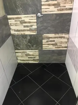 a bathroom with a black floor and a tile shower at Refugio Cumaná in San Rafael