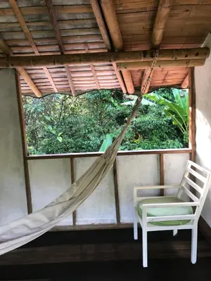 a hammock and a chair in a room with a window at Refugio Cumaná in San Rafael
