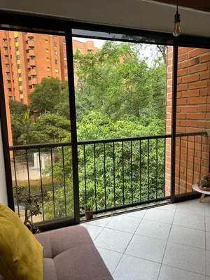 a room with a balcony with a view of trees at Casa Pantera in Medellín