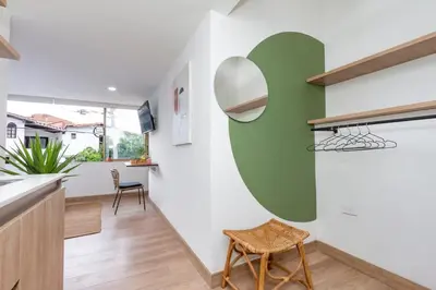 a kitchen with a green and white wall at Laureles Apt-Big Windows-Smart lock- AC in Medellín