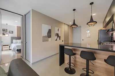 a kitchen and living room with a counter and stools at Next Avenue 702 - Apt with balcony and AC/Poblado in El Poblado