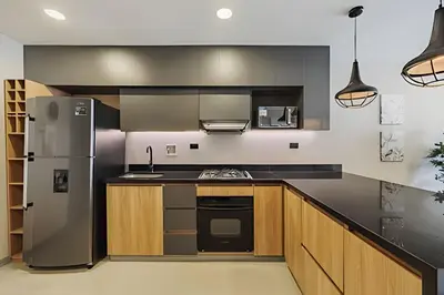 a kitchen with a stainless steel refrigerator and wooden cabinets at Next Avenue 702 - Apt with balcony and AC/Poblado in El Poblado