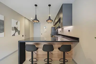 a kitchen with a large island with black counter stools at Next Avenue 702 - Apt with balcony and AC/Poblado in El Poblado