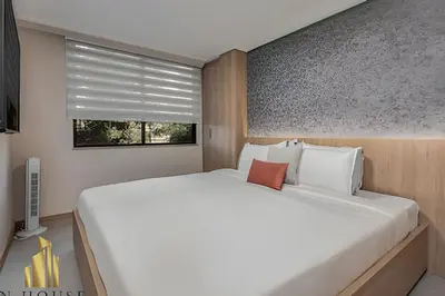 a bedroom with a large white bed and a window at Paola 201 - Charm and perfect location in Laureles in Guayaquil