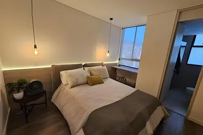 a bedroom with a bed with a desk and a window at Parma 2305 - Elegance in the Urban Heart / Poblado in El Poblado