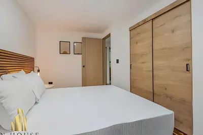 a bedroom with a large white bed and a wooden headboard at Poblado Del Campestre 203 - Comfort & Exclusivity in Envigado