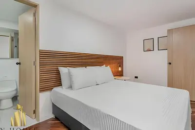 a bedroom with a large white bed and a toilet at Poblado Del Campestre 203 - Comfort & Exclusivity in Envigado