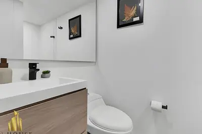 a white bathroom with a toilet and a sink at Poblado Sandiego 1505 - Cool off in style apt/pool in El Salvador
