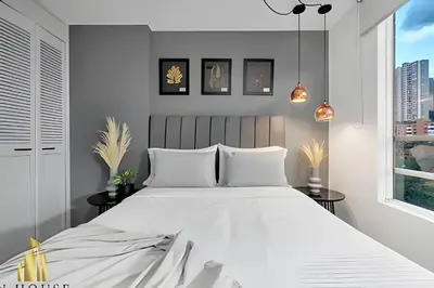 a bedroom with a large white bed and a window at Poblado Sandiego 1505 - Cool off in style apt/pool in El Salvador