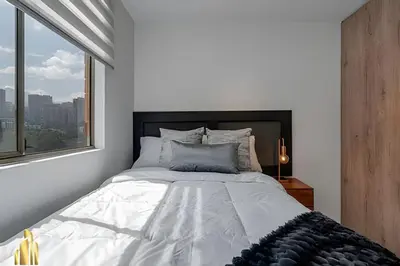 a bedroom with a large bed with a window at Portal de los Parra 1604 - Peaceful apt/Balcony in El Poblado