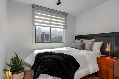 a white bedroom with a large bed and a window at Portal de los Parra 1604 - Peaceful apt/Balcony in El Poblado