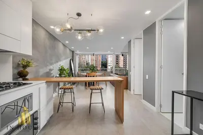 a kitchen with a wooden table and stools at Provenza Life 1001 - Airy apt w priv balcony & gym in El Poblado