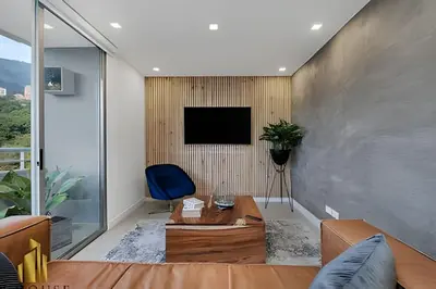 a living room with a couch and a tv on a wall at Provenza Life 1001 - Airy apt w priv balcony & gym in El Poblado