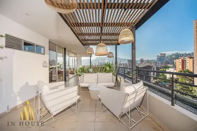 a balcony with white chairs and a view of the city at Provenza Life 1002-Tastefully decorated loft/gym in El Poblado