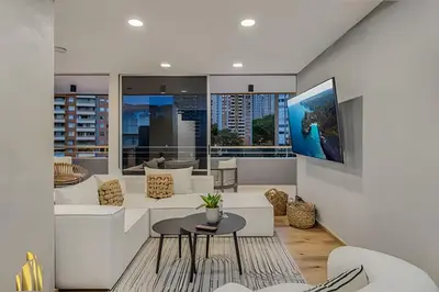a living room with white furniture and a large window at Provenza Life 1002-Tastefully decorated loft/gym in El Poblado