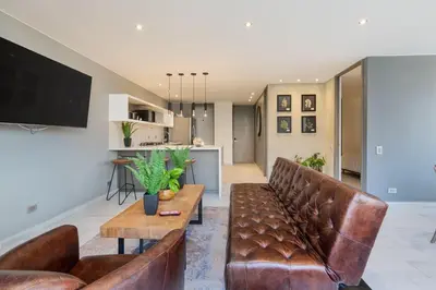 a living room with brown leather furniture and a tv at Provenza Life 1003 - Airy Loft with abundant light in El Poblado