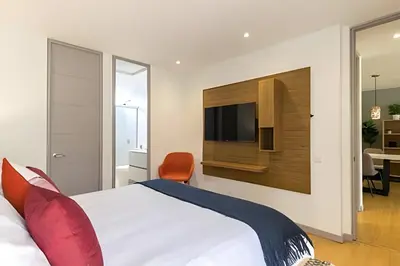 a bedroom with a bed and a television on a wall at Provenza Life 501 - Apt in the heart of Provenza in El Poblado